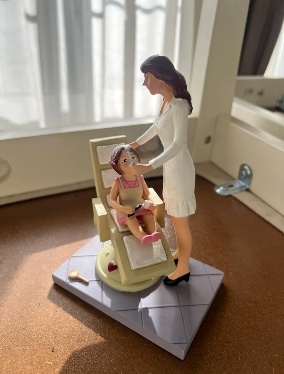 A Female Dentist Sculpture Treating her Baby Patient